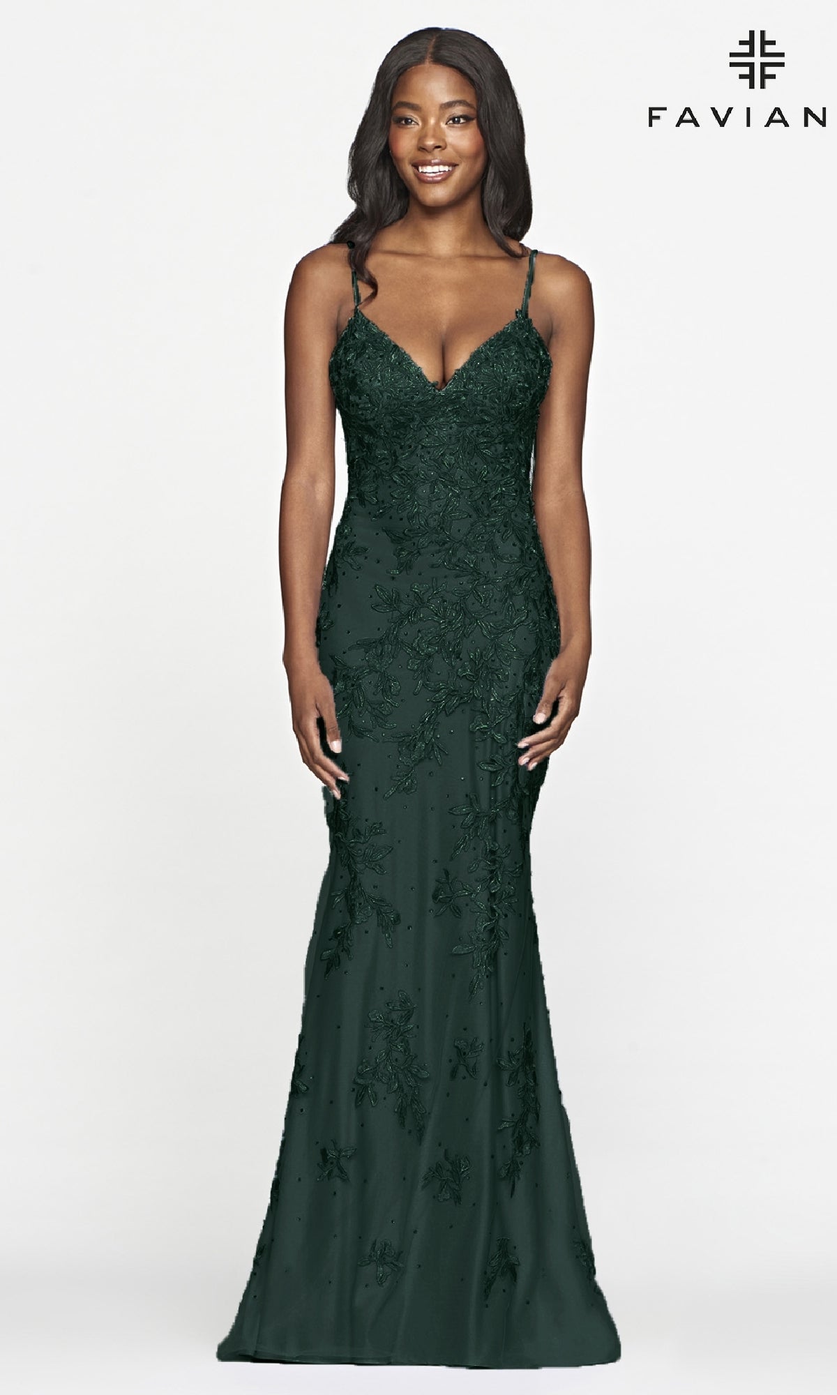 A woman poses against a white background in the Faviana Lace Embroidery Long Backless Prom Dress, a fitted, dark green, floor-length gown with intricate beadwork, lace embroidery, thin straps, and a slight flare at the hem.